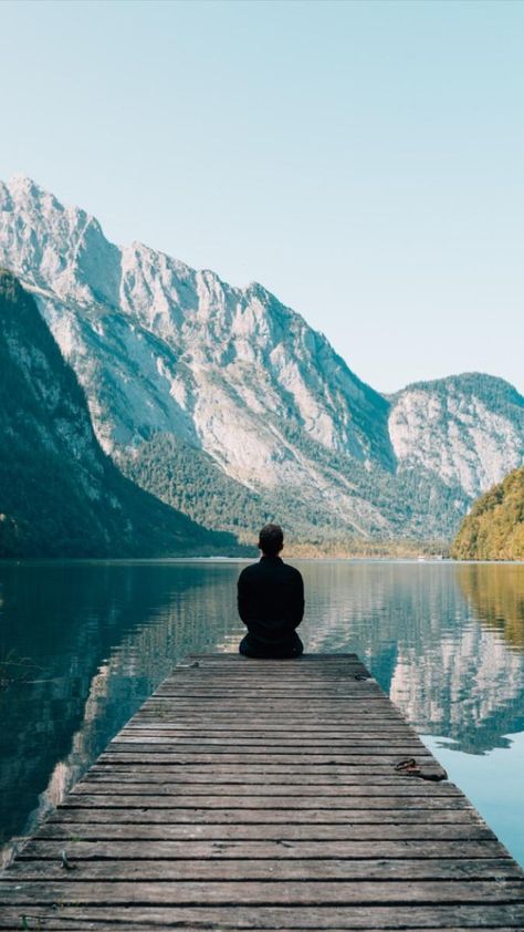 Erwachsene Person geht in einem Stadtpark auf einem Weg zwischen Bäumen